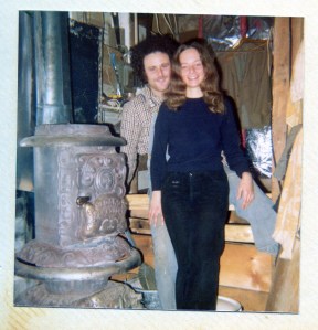 Maine, 1974. Julie & Richie cozying up to the wood stove on their organic farm.
